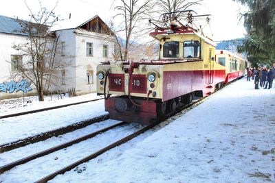 View of railroad tracks by building during winter