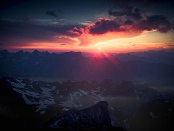 Scenic view of snowcapped mountains against sky during sunset