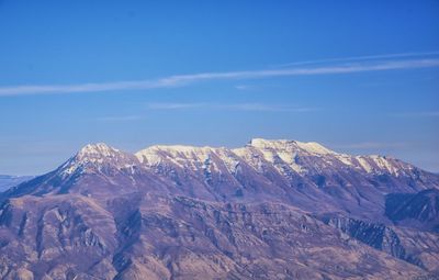 Scenic view of snowcapped mountains against blue sky