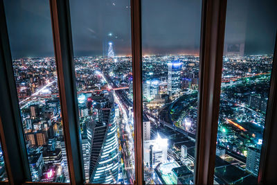 High angle view of illuminated modern buildings in city at night