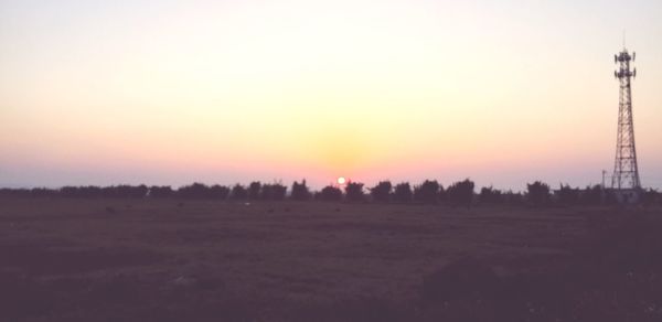 Scenic view of field against clear sky during sunset