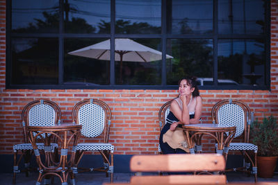 Young woman sitting at restaurant table