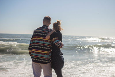 Rear view of couple standing on beach