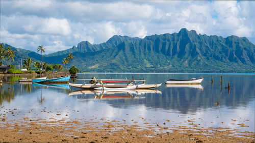 Boats moored in lake against sky