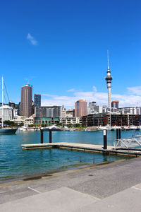 View of modern buildings in city against blue sky