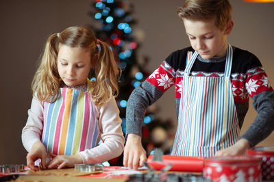 Siblings preparing cookies at home