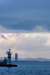 Lighthouse by sea against sky