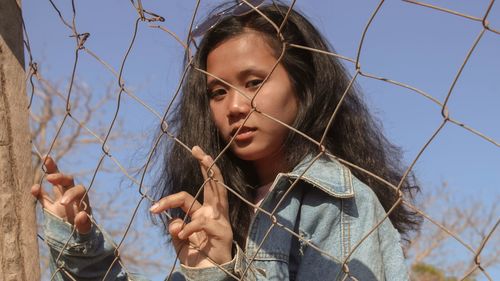 Portrait of woman holding girl against sky