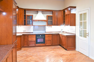 Spacious kitchen with wooden furniture and light walls,