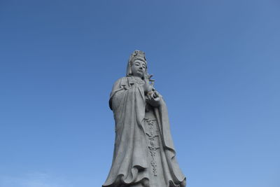 Low angle view of statue against blue sky