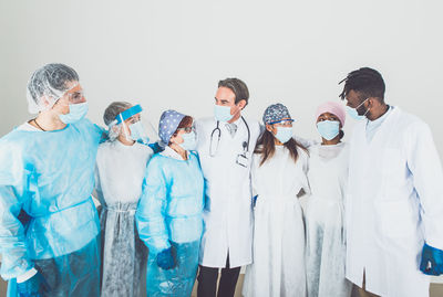 Group of people standing against white wall