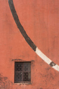 Window amidst red wall