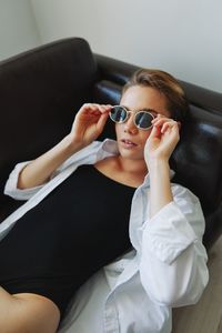 Portrait of young woman using mobile phone while sitting at home