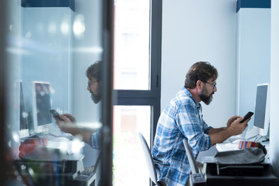 Side view of young man working in office