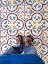 Low section of man standing on tiled floor