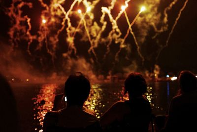 Rear view of silhouette people at fireworks show