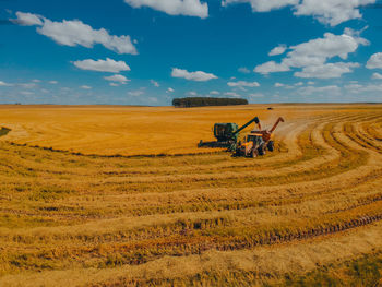 Hay bales on field against sky