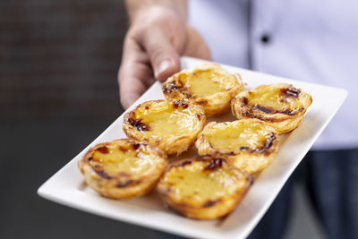 Close-up of hand holding food in plate