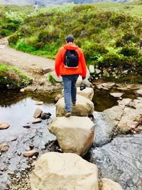 Rear view of man standing by rocks