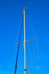 Low angle view of sailboat against clear blue sky