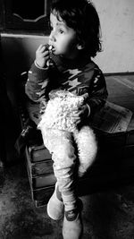 Girl looking away while sitting on table