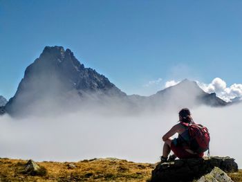 Rear view of man looking at mountain against sky