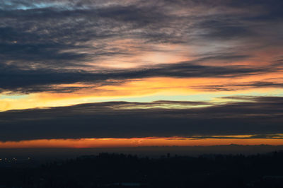 Scenic view of dramatic sky over silhouette landscape