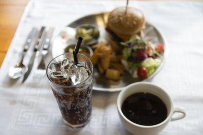 High angle view of burger and salad with drinks on table