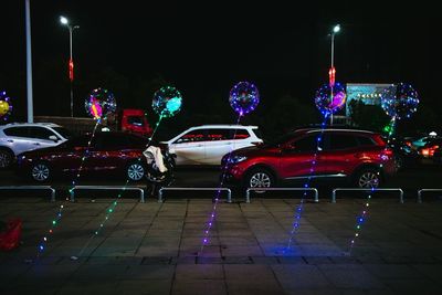 Cars on illuminated street at night