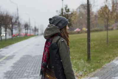 Close-up of woman standing on footpath against sky during winter