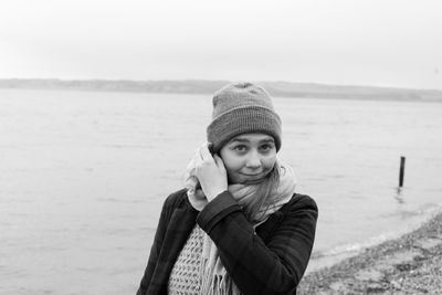 Portrait of smiling young woman in sea during winter