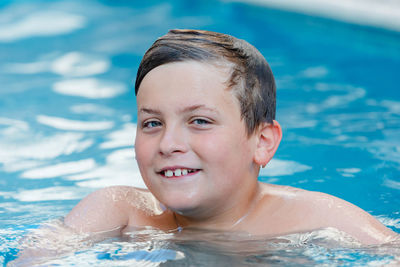 Portrait of shirtless boy swimming in pool