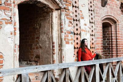 Woman standing in balcony at historic place