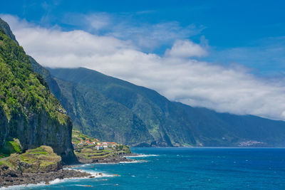 Scenic view of sea and mountains against sky