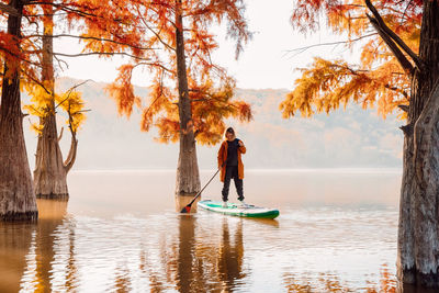 Rear view of woman standing in lake