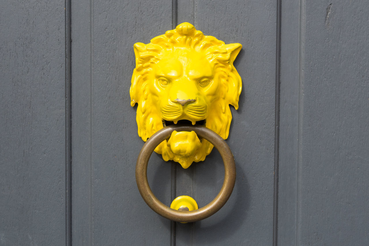 CLOSE-UP OF YELLOW DOOR WITH CLOSED METAL