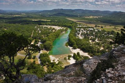 High angle view of river amidst field against sky