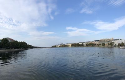 Scenic view of lake by buildings against sky