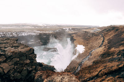 Scenic view of waterfall against sky