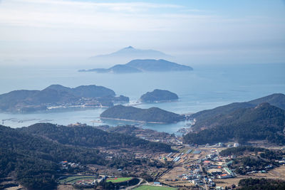 High angle view of cityscape by sea against sky