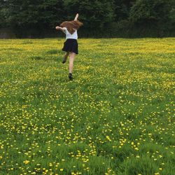 Woman walking on grassy field