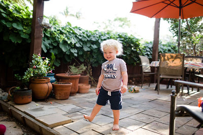 Full length of boy standing against plants