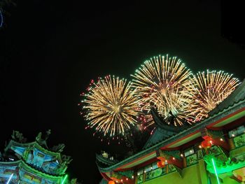 Low angle view of firework display at night
