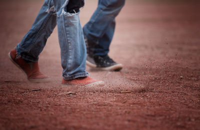 Low section of men walking on field