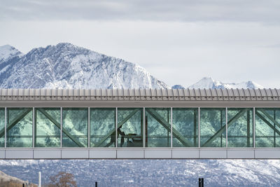 Built structure by snowcapped mountains against sky