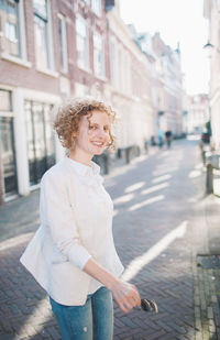 Cheerful woman walking on street in city