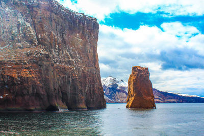 Rock formations by sea against sky