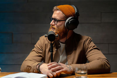 Male podcaster interviewing a guest in a recording studio