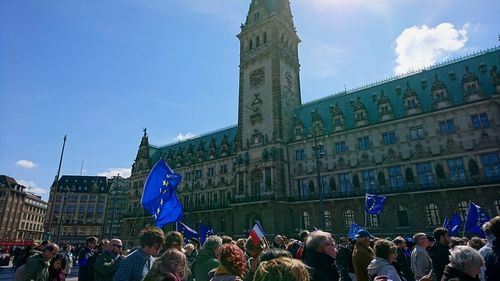 People at town square against blue sky