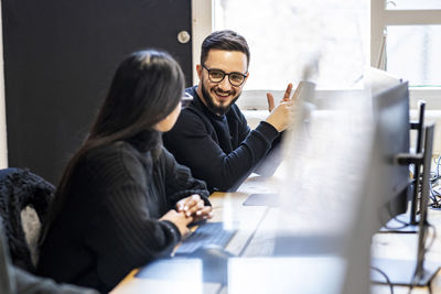 Happy businessman talking to colleague in office